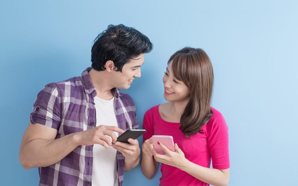 スマートフォンを見ながら話す2人